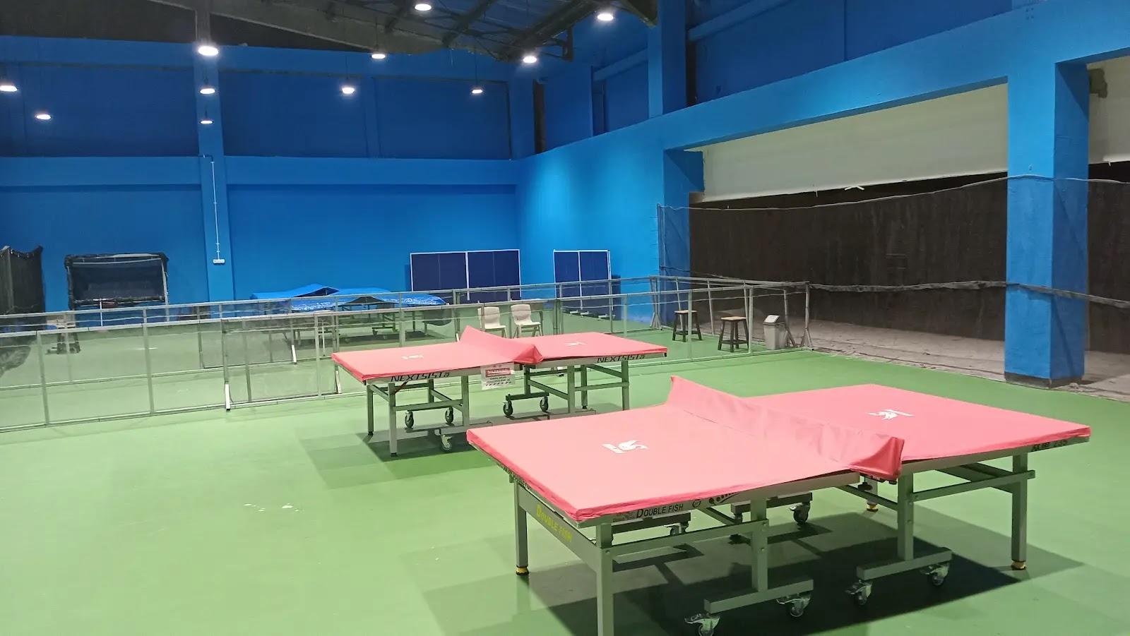 Indoor table tennis hall with red covered tables