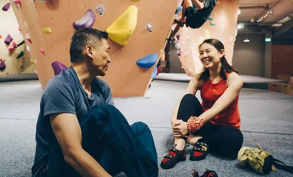Two climbers sitting and chatting at indoor bouldering gym