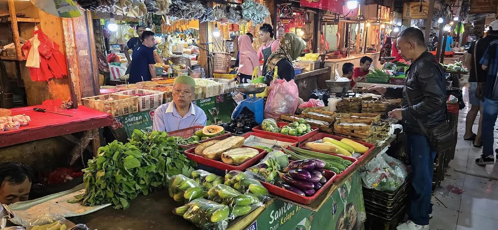 busy indoor vegetable market stall with vendor
