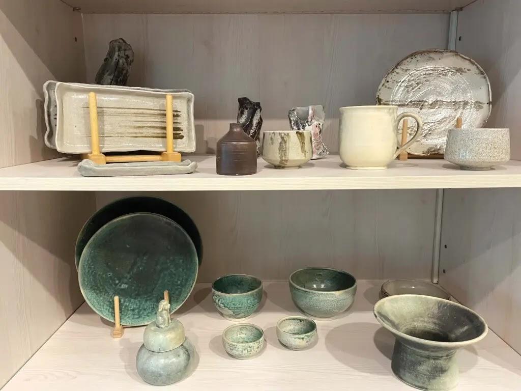 ceramic pottery display of bowls on wooden shelf