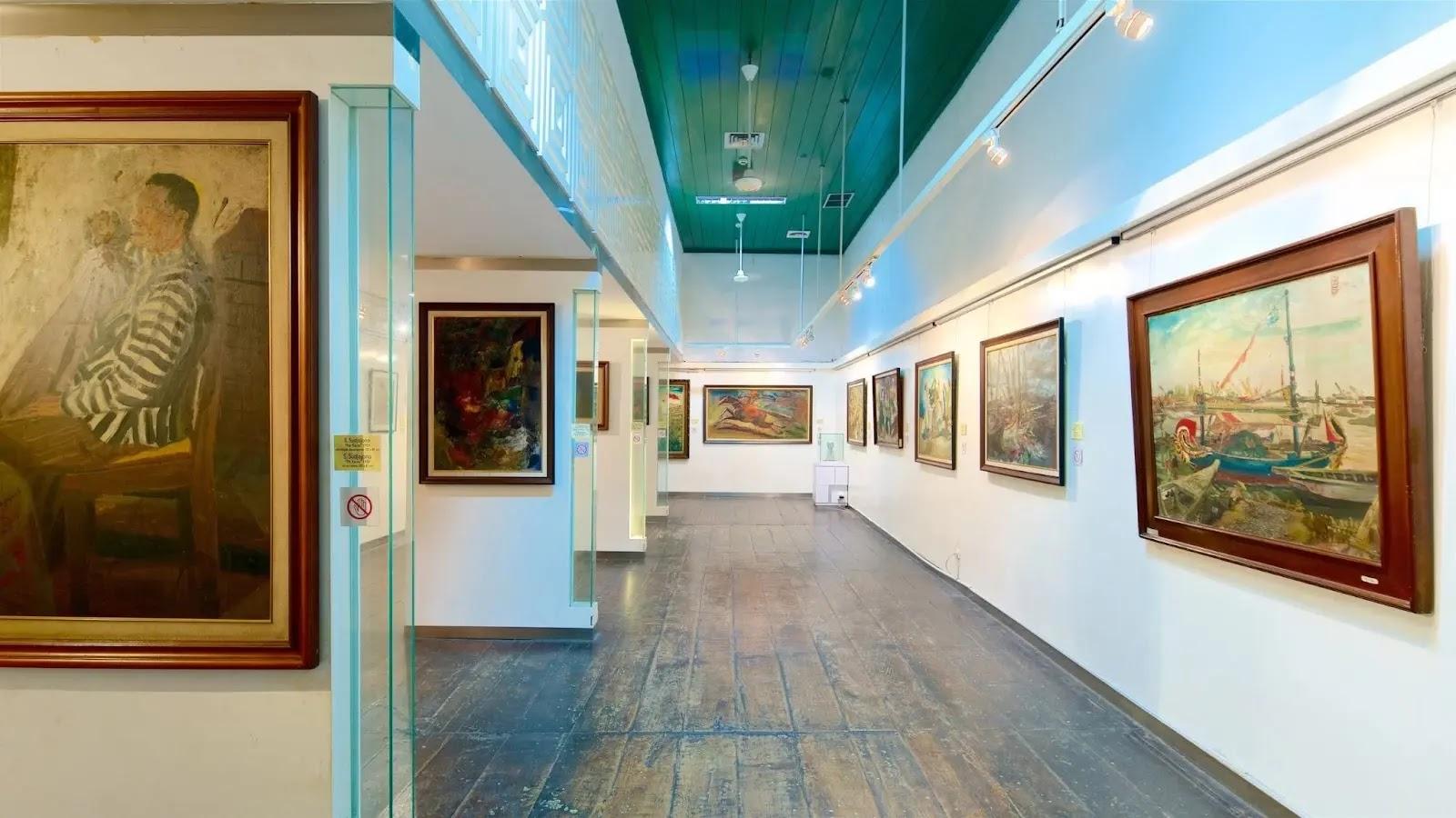art gallery interior with framed paintings and wooden floor