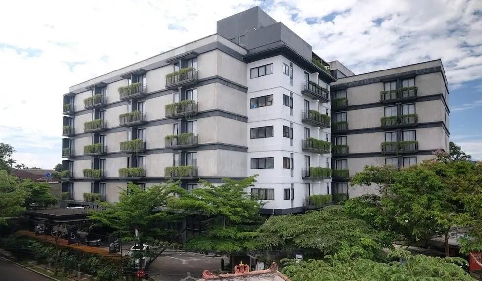 Modern mid-rise apartment building with balcony greenery