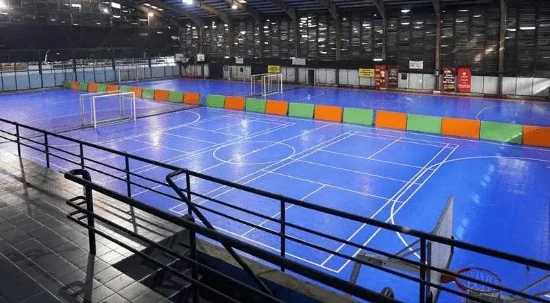 Empty indoor futsal court with bright blue floor