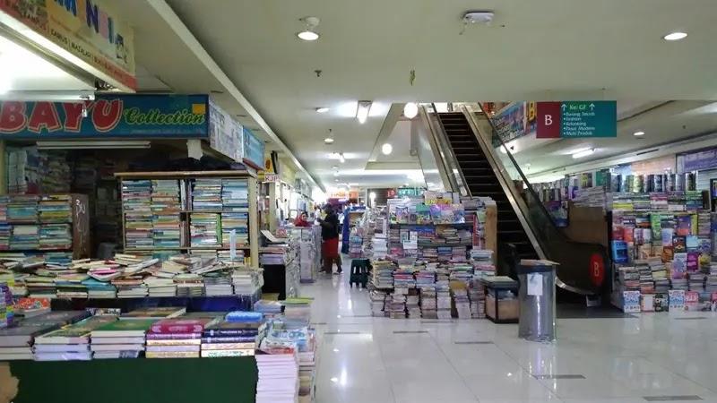 indoor bookstore stall with stacks of books and escalator