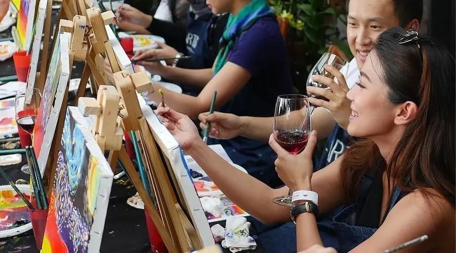 People painting and sipping wine at a paint and sip event