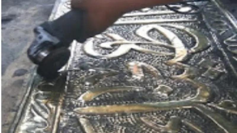 gloved hand polishing embossed Arabic metal plaque