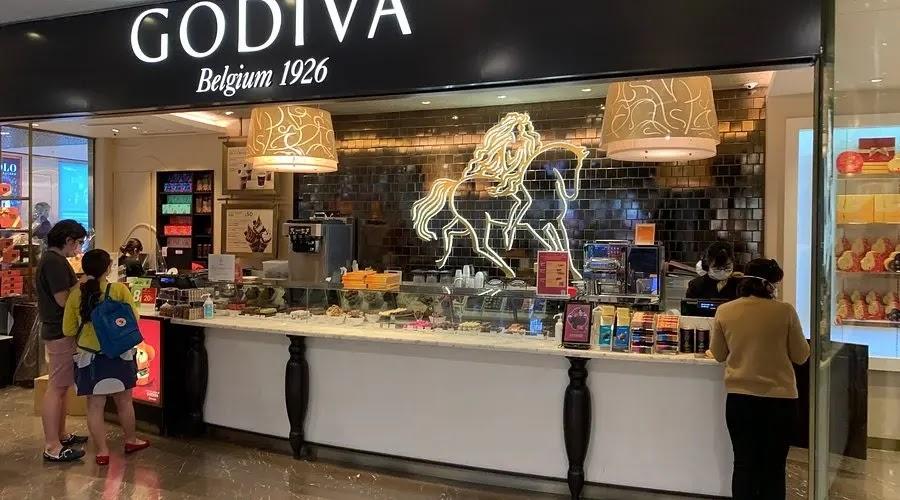 GODIVA logo and chocolate shop counter with customers