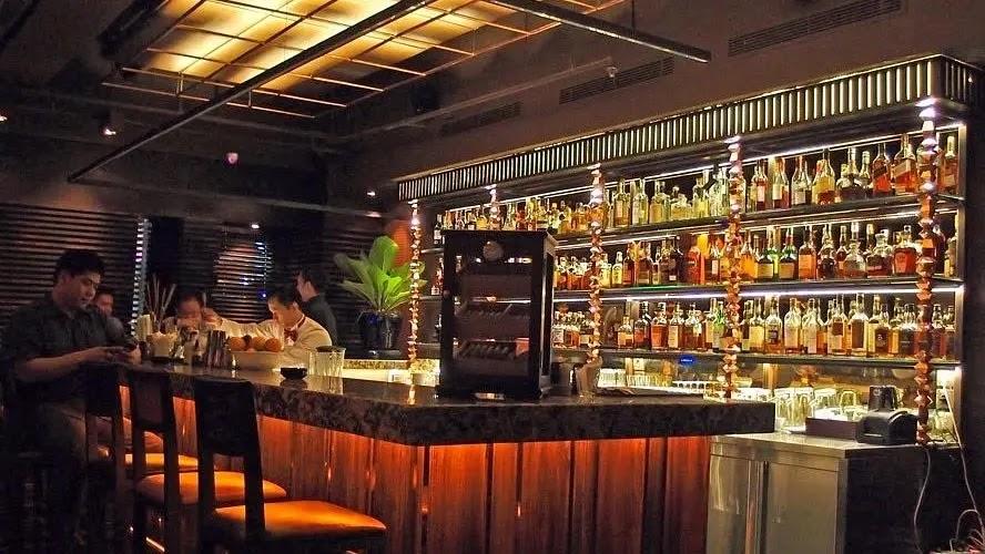Cozy dimly lit bar with illuminated liquor shelves