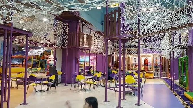 Indoor purple playground with overhead nets and seating