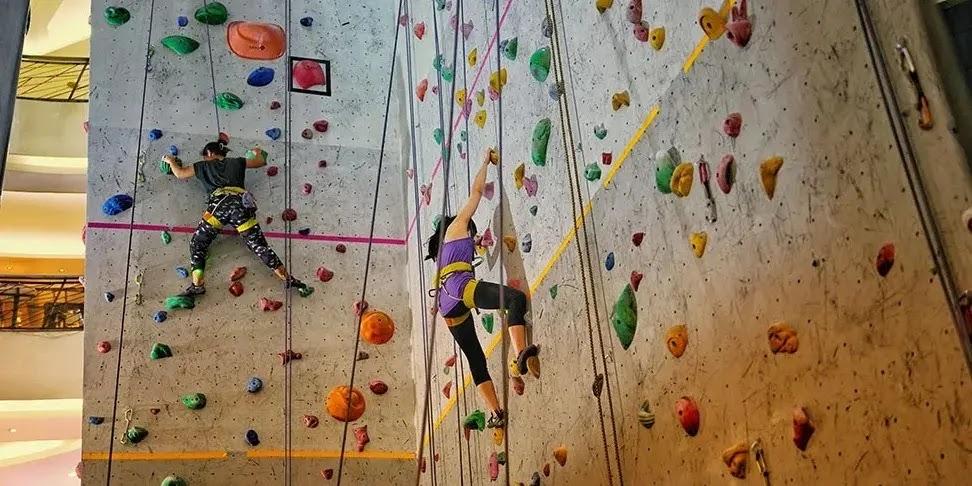 Two climbers scaling colorful indoor rock climbing wall