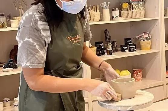 Person shaping a clay pot at ceramics studio