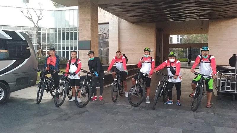 Cycling group in red and white jerseys with bikes