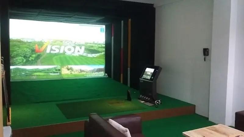 Indoor golf simulator room with Vision logo on screen