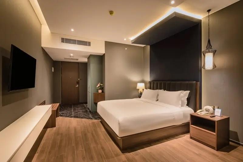 Modern hotel bedroom with king bed and TV