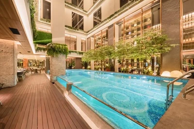 Hotel indoor pool with wooden deck and greenery