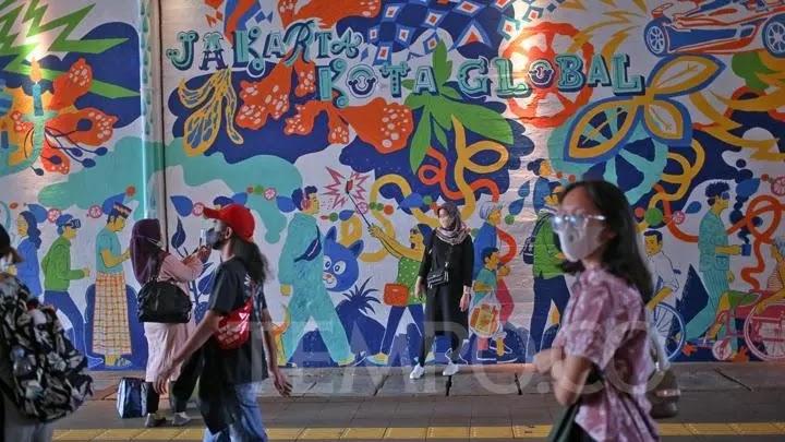 Jakarta Kota Global mural behind pedestrians