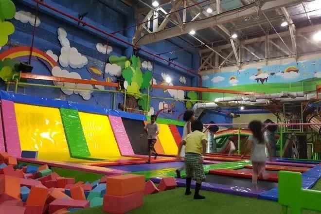 Kids playing in indoor trampoline park with bright colors