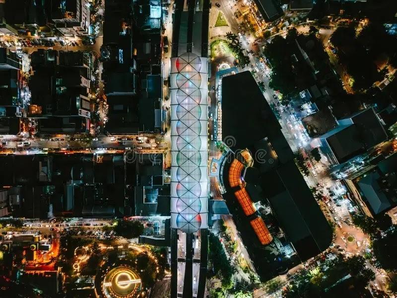 Aerial night view of illuminated covered market and streets