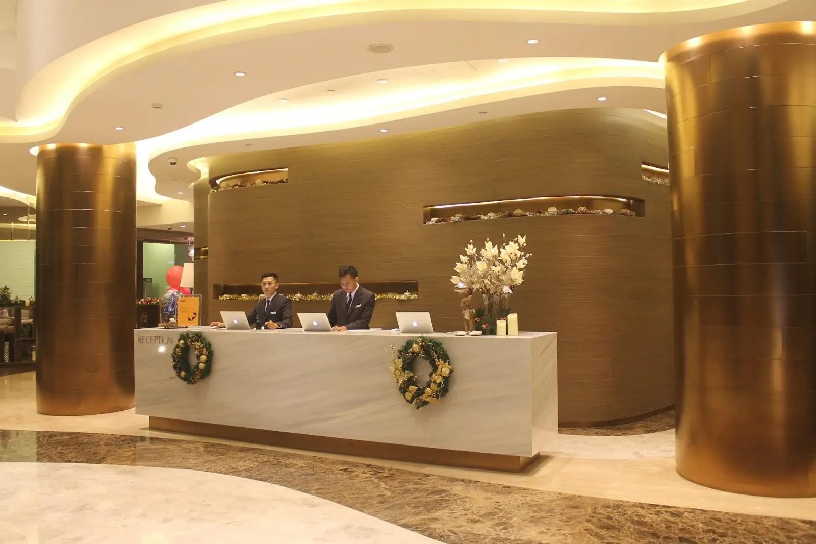 hotel reception desk with two staff and wreaths