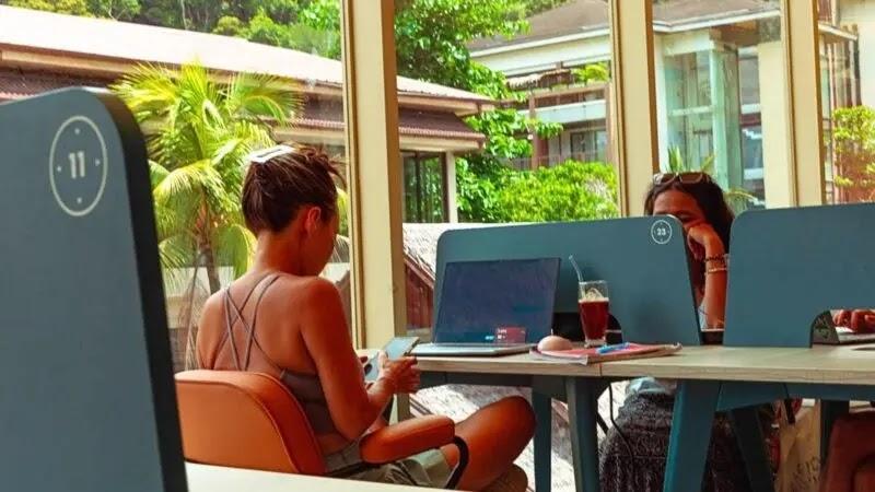 Two women in a co-working cafe working on laptops