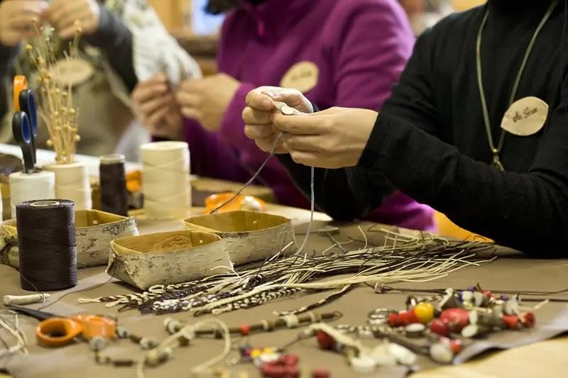 People handcrafting beaded jewelry at craft table