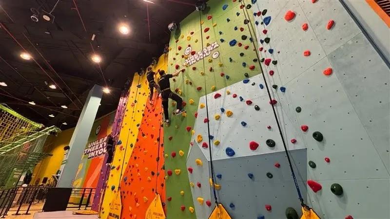 Indoor rock climbing wall with climbers and colorful holds