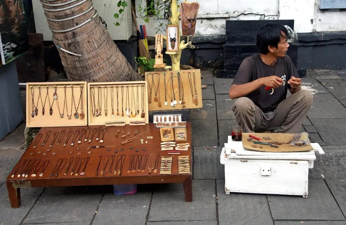 street vendor selling wooden necklaces and pendants