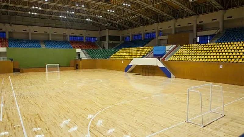 Empty indoor sports arena with wooden floor and small goals