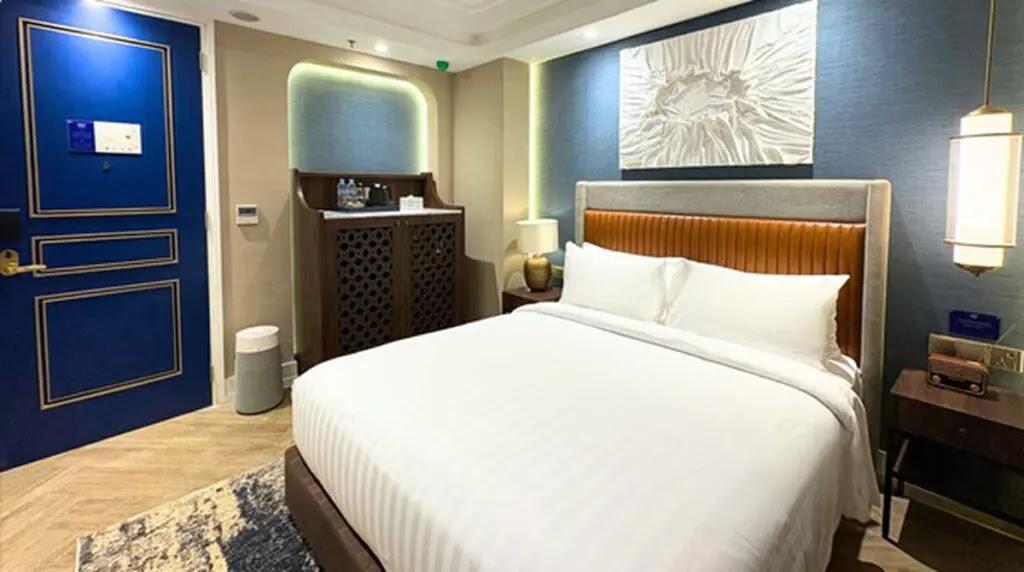 Hotel bedroom with king bed and blue door