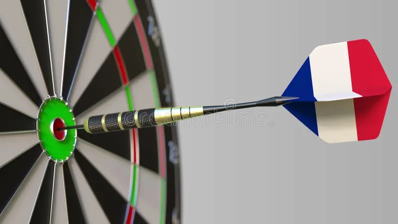 Dartboard bullseye with dart and French dart stuck in dartboard, close-up view