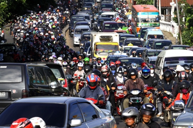 Busy traffic congestion with many motorcycles and cars on a crowded city street
