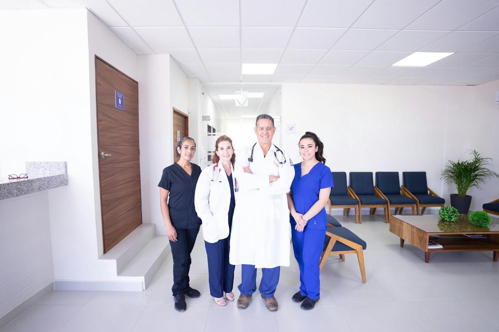 Medical team of doctors and nurses in a modern clinic waiting room with blue chairs and wooden benches