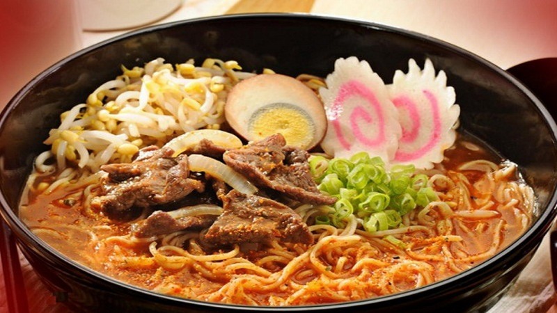 Hearty ramen bowl with sliced pork, soft-boiled egg, narutomaki, green onions, and bean sprouts