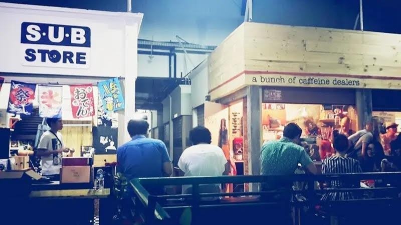 S.U.B. Store street stall with banners and people gathered in a bustling Japanese market scene
