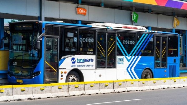 Blue and white Lansik Lanka city bus parked at a curb with route signage and colorful station background