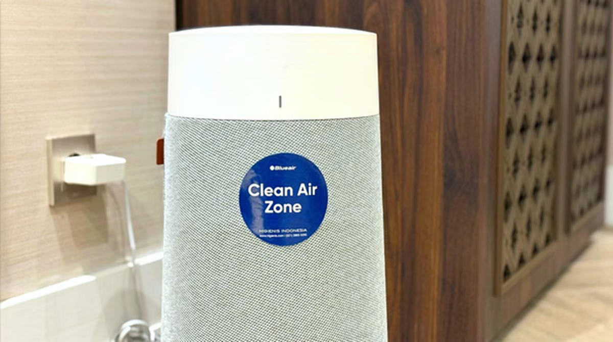 Clean Air Zone air purifier with blue logo on a white and gray device in a modern interior hallway