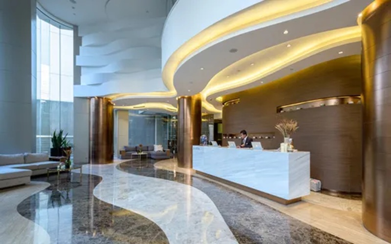 Luxury hotel reception desk with gold illuminated arches and marble lobby floor, modern interior view
