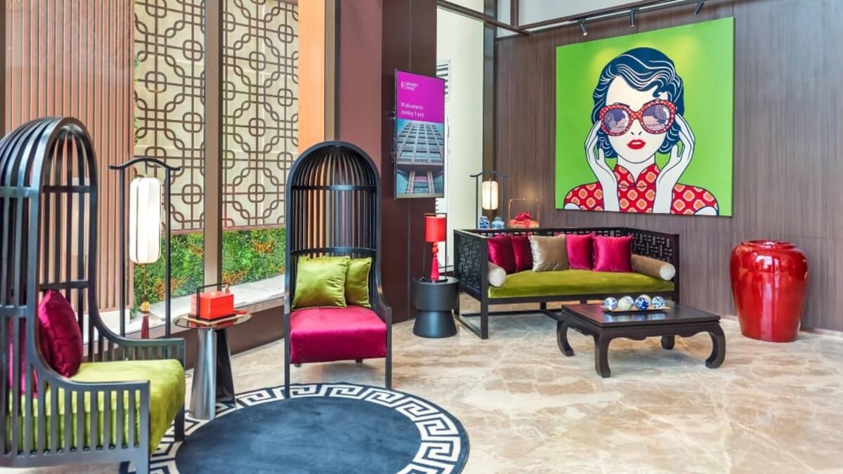 Modern luxury lounge interior with green and pink seating, patterned décor, and bold pop art wall artwork
