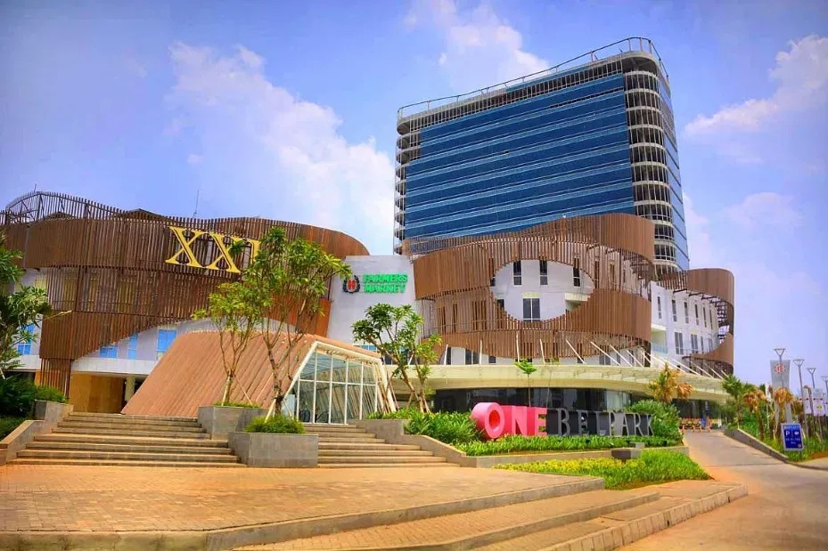 On Free Lab building entrance with modern glass tower, landscaped steps, and sky backdrop
