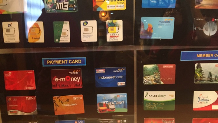 Close-up of payment card display with Mandiri, e-Money, Indomaret, BNI and TapCash cards