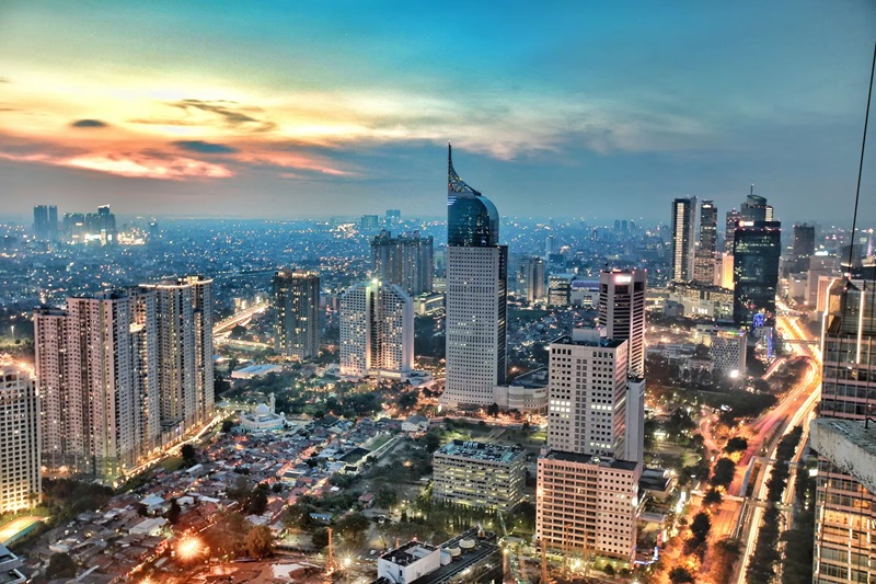 Bangkok city skyline at dusk with tall skyscrapers, including Baiyoke Tower, and glowing streets