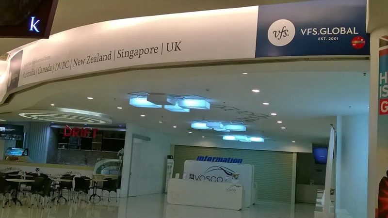 VFS Global passport service entrance with information counter and illuminated signage in a modern office corridor