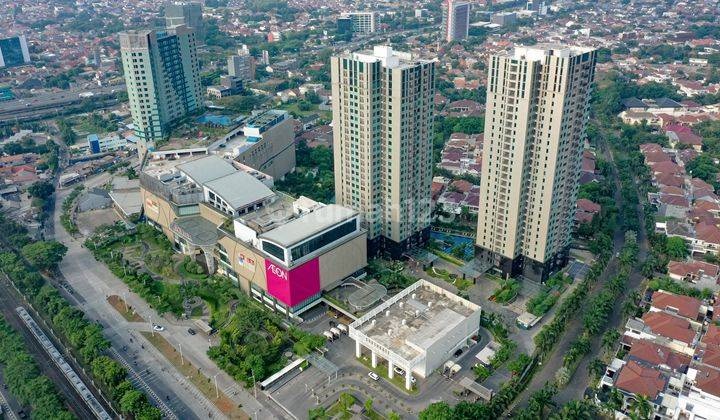 Aerial view of an urban area with tall apartment towers and a shopping mall parking lot