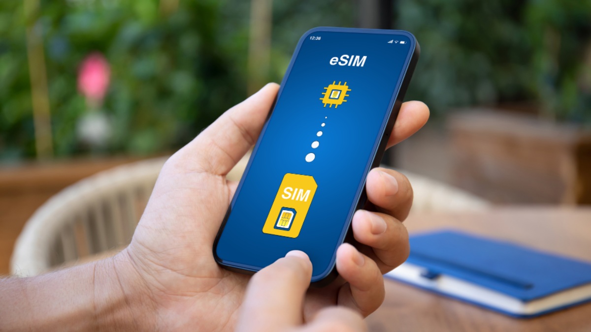Hand holding smartphone displaying eSIM activation screen with SIM profile icons outdoors