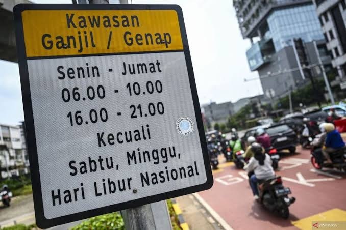Papan pengumuman Kawasan Ganjil Genap dengan jadwal Senin-Jumat dan Sabtu-Minggu di area perkotaan