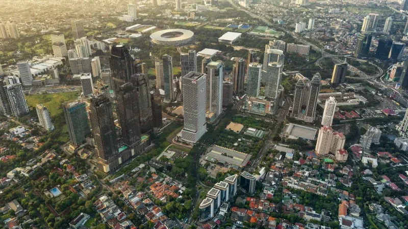 Aerial view of a dense city skyline with skyscrapers, neighborhoods, and roads stretching across downtown