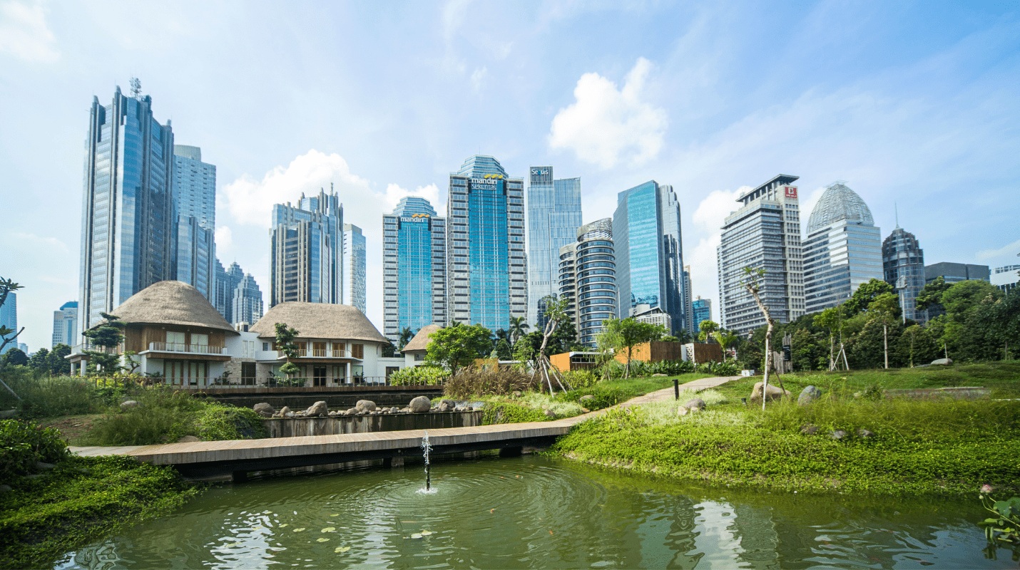 Modern skyline with tropical buildings and a pond with fountain in a landscaped park, city center