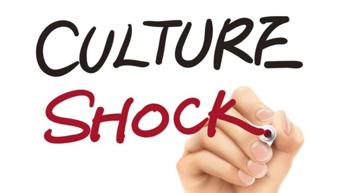Culture shock with hand writing “Shock” using a pen, “CULTURE” above on white background