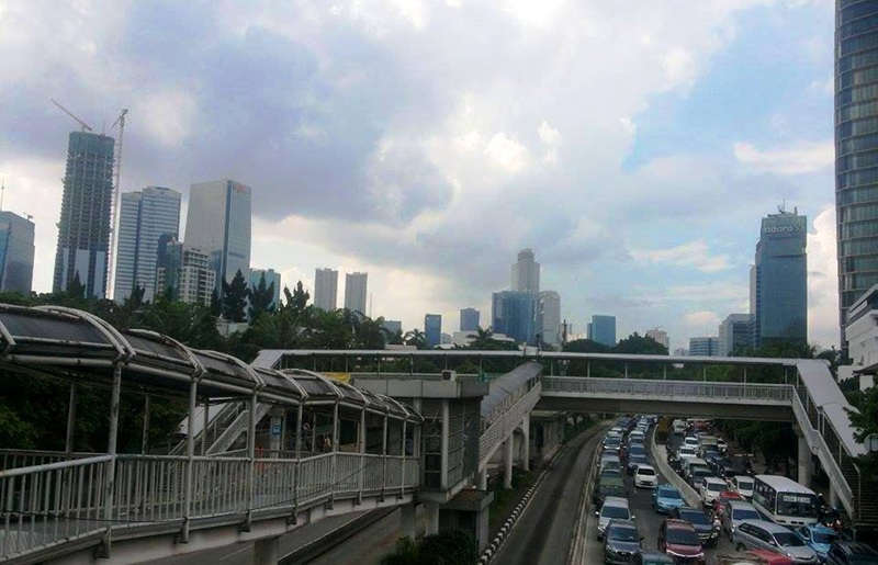 Los Angeles downtown freeway with elevated ramps and heavy traffic, skyscrapers under cloudy sky