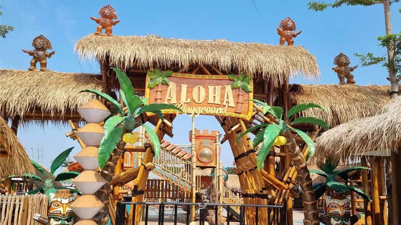 Tao hạônga playground entrance with thatched roofs, carved tiki figures, and colorful animal-themed archway